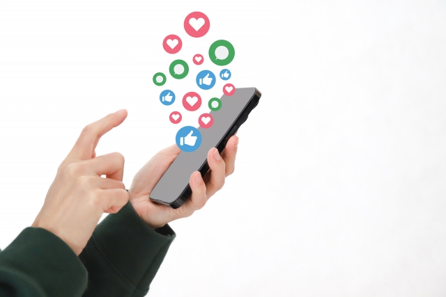 スマートフォンを手に持ち、画面を操作している様子