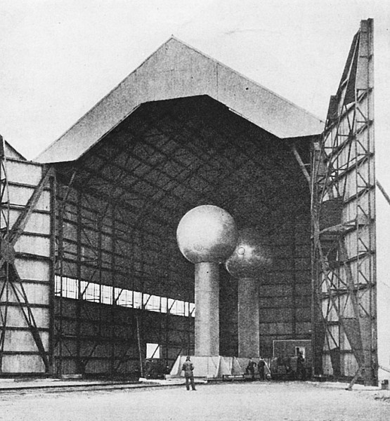 The Van de Graaff generator, shown housed in an aircraft hangar, is discussed by Dr. Tesla in the accompanying article.