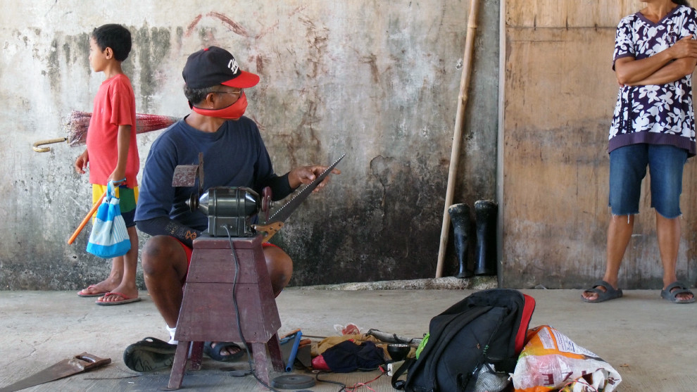 Saw-grinder in a busstation, Ormoc, Philippines