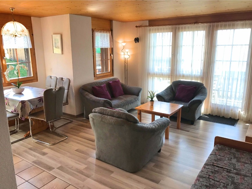 Wohnzimmeransicht mit Sofa und TV in der Sonnenhalde C12 auf der  Riederalp