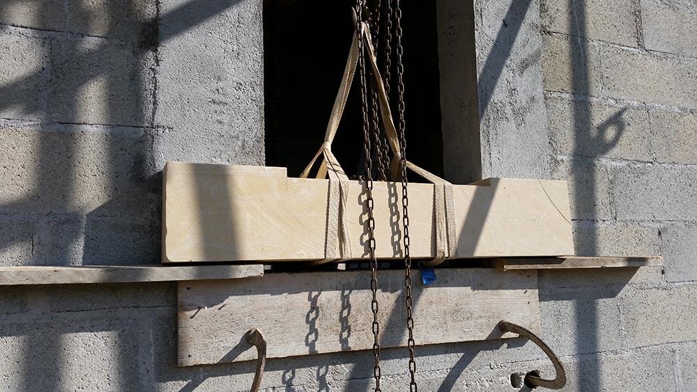 Construction des écuries du château, pose d'un appui de fenêtre en pierre