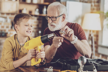 Opa erklärt Enkel etwas zu einem Werkzeug