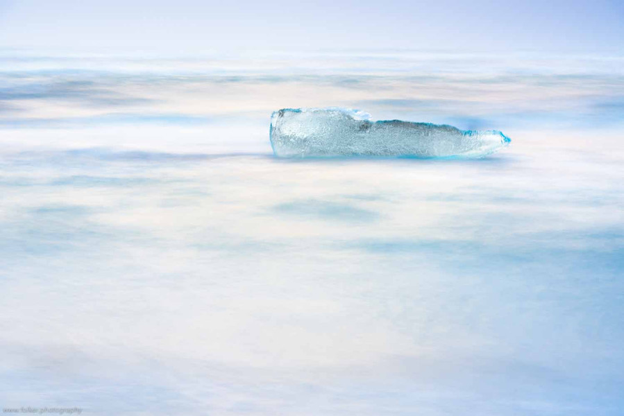  „Drifting“, Folker Michaelsen - aufgenommen auf Island bei kaltem Sonnenuntergang im Februar 2015. Die Leichtigkeit eines über das Wasser schwebenden Eisblocks, ca. 5m langen Eisblocks.  Fotoprint auf Alu-Dibond hinter Acryl-Glas, ca. 75 x 50 cm