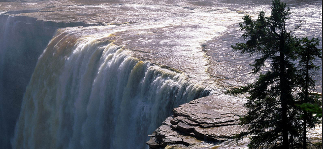 De bovenkant van een grote waterval waar je het water naar beneden ziet vallen