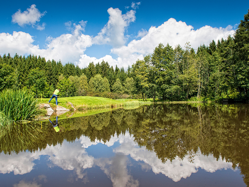 Golfer an einem See.