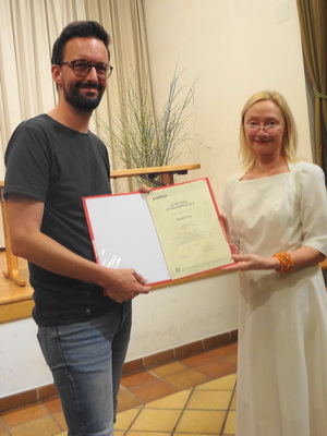 Überreichung der Preisurkunde an David Fuchs durch Barbara Neuwirth (Podium)