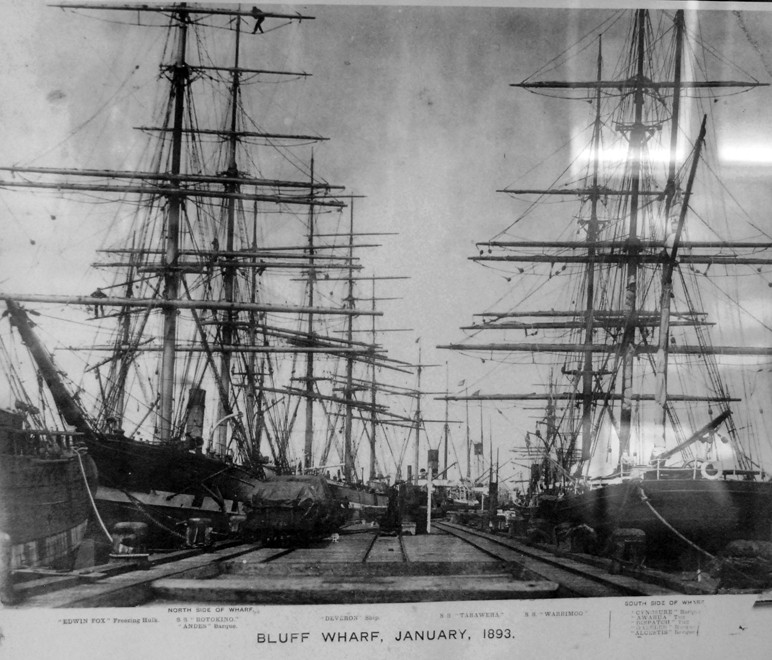 Sailing ships tied up to the Bluff Wharf in 1893. Two foremost ships (L) SS Rotokino and (R) SS Warimoo plus 4 barques, 2 tugs, 1 ship and 1 freezing hulk (from South Sea Hotel, Stewart Island).