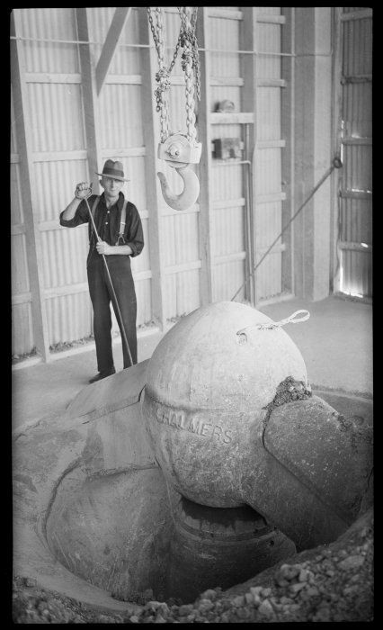 A worker beside pulley hook and grinder inside the Golden Bay Cement Works, Tarakohe. Photograph taken circa 1939, by Thelma Rene Kent.(Click for source)