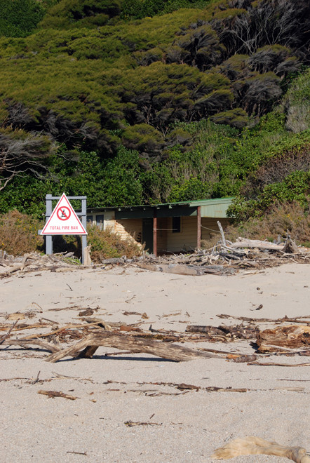 Bach and total fire ban on the Taupo Head walk, Golden Bay.The high tide path descends through the manuka/kanuka bush behind the bach.