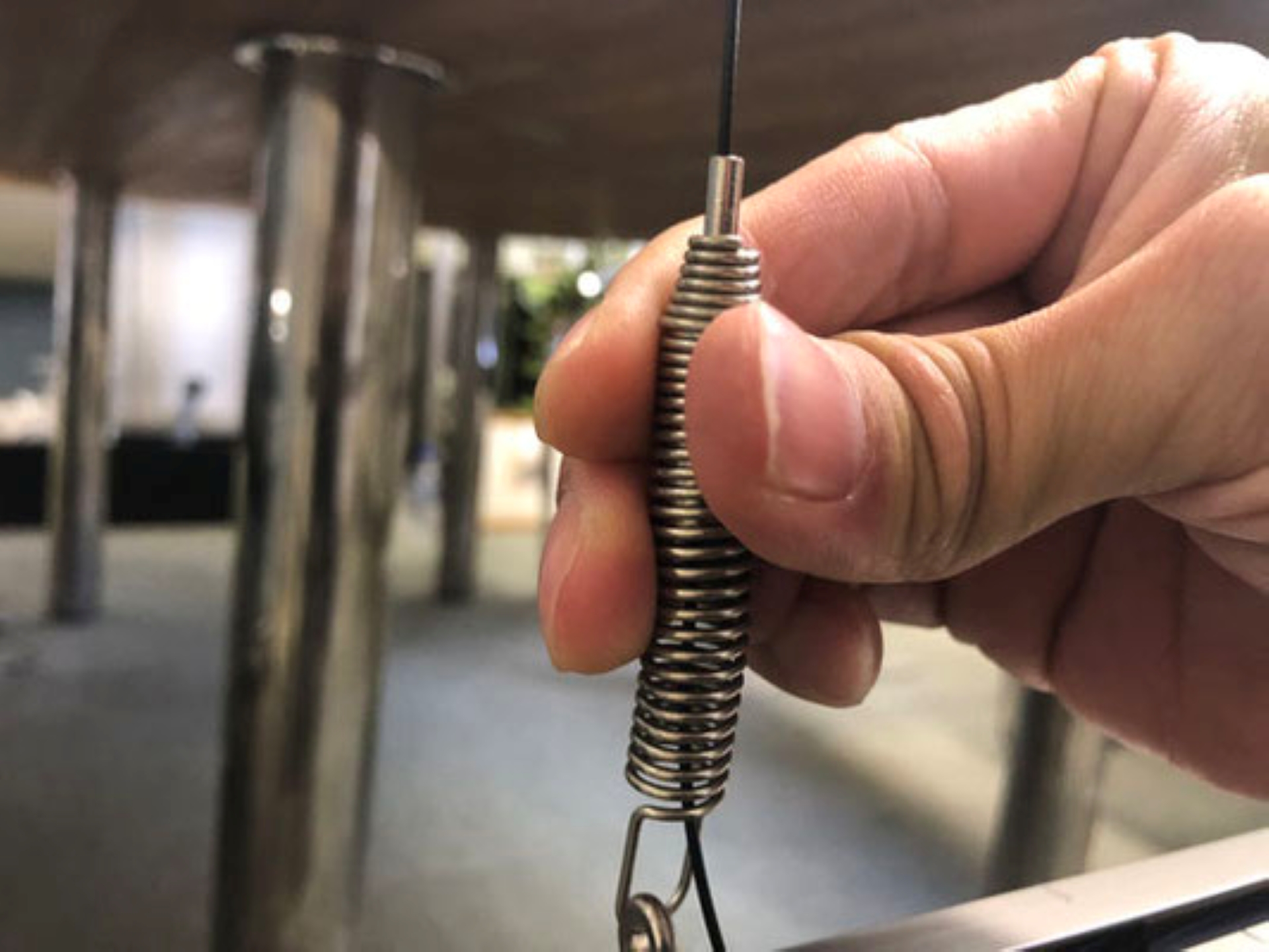 6.  ワイヤーのバネ＋アタッチメント側を下端レールの端(穴)から差し込む。先端ピンは押さず、バネ部を上に持ち上げながら、ワイヤーを適度なテンションになるまで引っ張る。引っ張った箇所でワイヤーはロックされ、余分なワイヤーはカットするか、レール内に入れる。ワイヤーの長さ調整はバネ部を上に持ち上げながら、バネ部先端のピンを押す事で調整出来る。ワイヤーにテンションがかなりかかっているので、何度も繰り返す。 