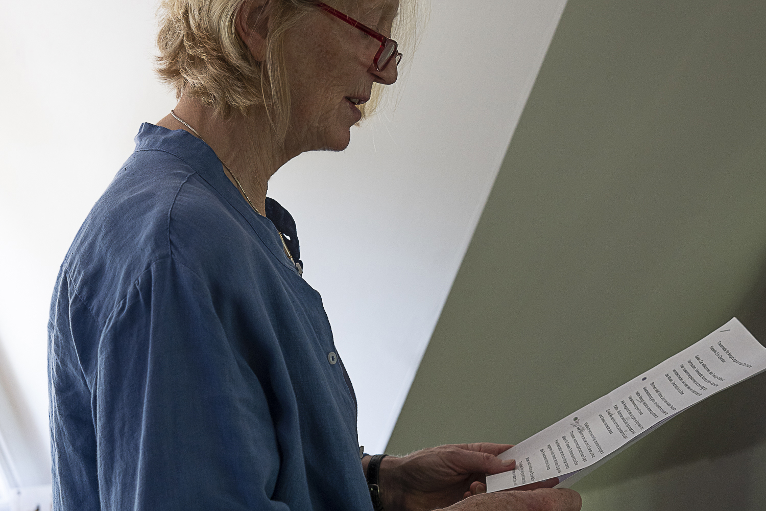 Die Trauerrednerin Stefanie Viereck hält ihre fertige Rede auf einem Papierausdruck in der Hand und liest sie laut vor, um den Text zu überprüfen. Sie übt ihre Ansprache für eine Trauerfeier ein.