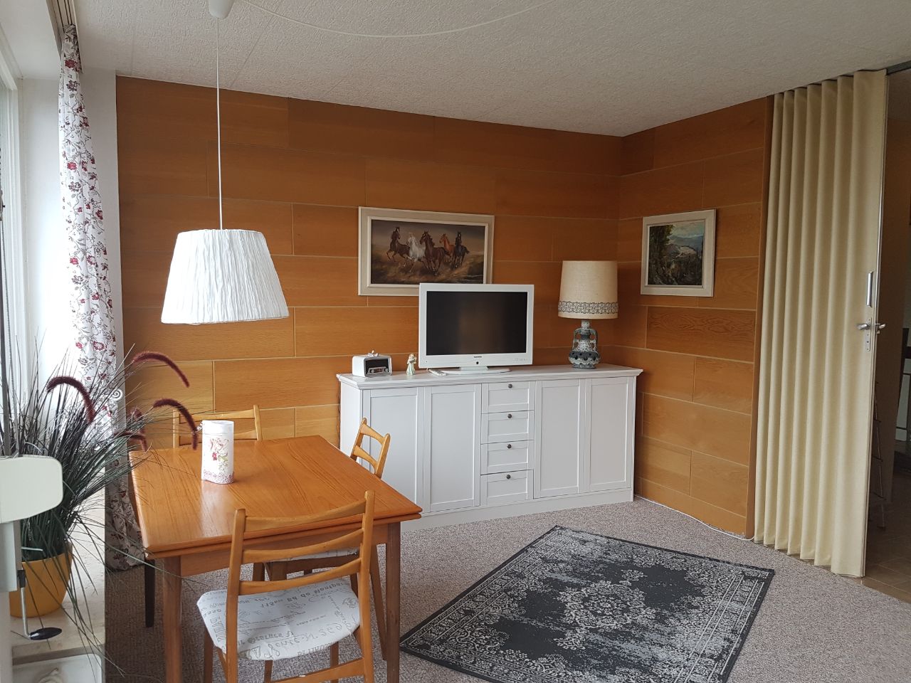 Wohnzimmer mit Esstisch vor dem Balkon