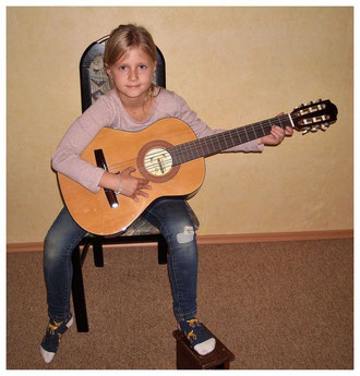 junge Gitarristin mit Kindergitarre