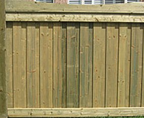 Overlapping privacy boards are framed by 6x6 capped posts and top-trimmed with a scalloped convex 2x4. Ensure stability by adding a beefy 2x6 bottom frame. 