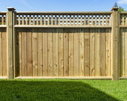  Elevate an ordinary cedar privacy fence by adding decorative capped posts in between the panels and a striking square lattice panel on top. 