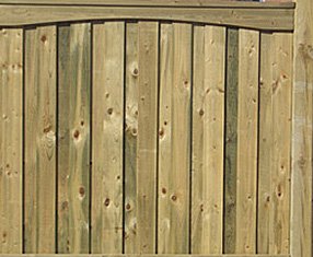 Add a decorative touch to your 6-foot privacy fence with a convex scallop trim piece on top. The overlapping boards are flanked by capped 6x6 posts. 