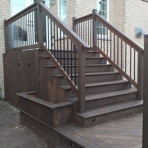 Accented with a charming planter box, this classic set of stairs leading up to a landing frames a small entryway and maximizes storage space under the deck for yard and garden tools. 