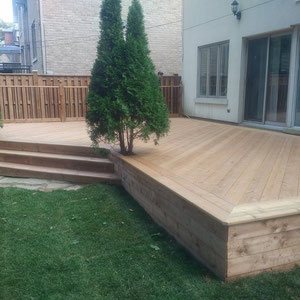 This sprawling platform deck extends the home’s living space while embracing the natural beauty of the back yard by wrapping around the existing landscape. 