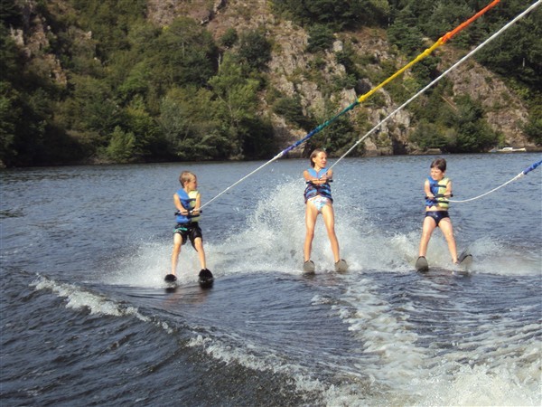 trois jeunes skieurs tractés en bi-ski