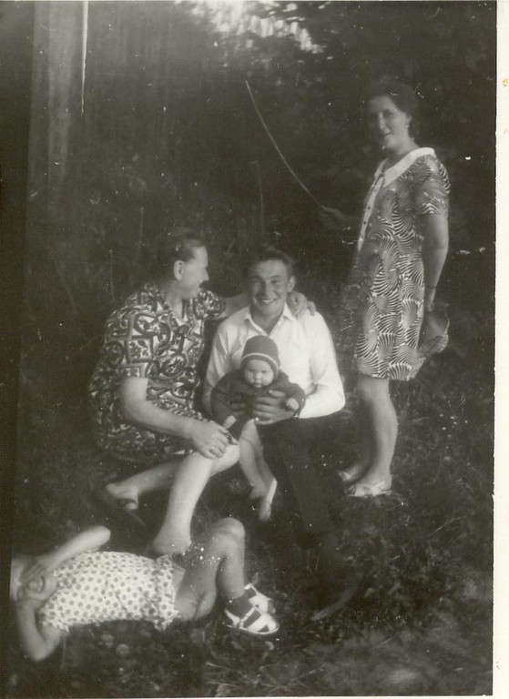 Maria auf dem Schoß des Papas, links Oma, rechts Tante Maria im Gras Genia