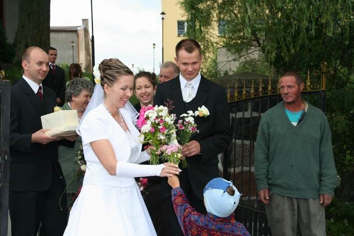 Vor der Kirche übergeben kleine Kinder der Braut Blumen