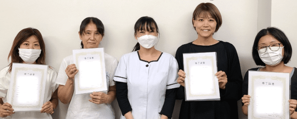 東京会場で修了証を持つ生徒と講師