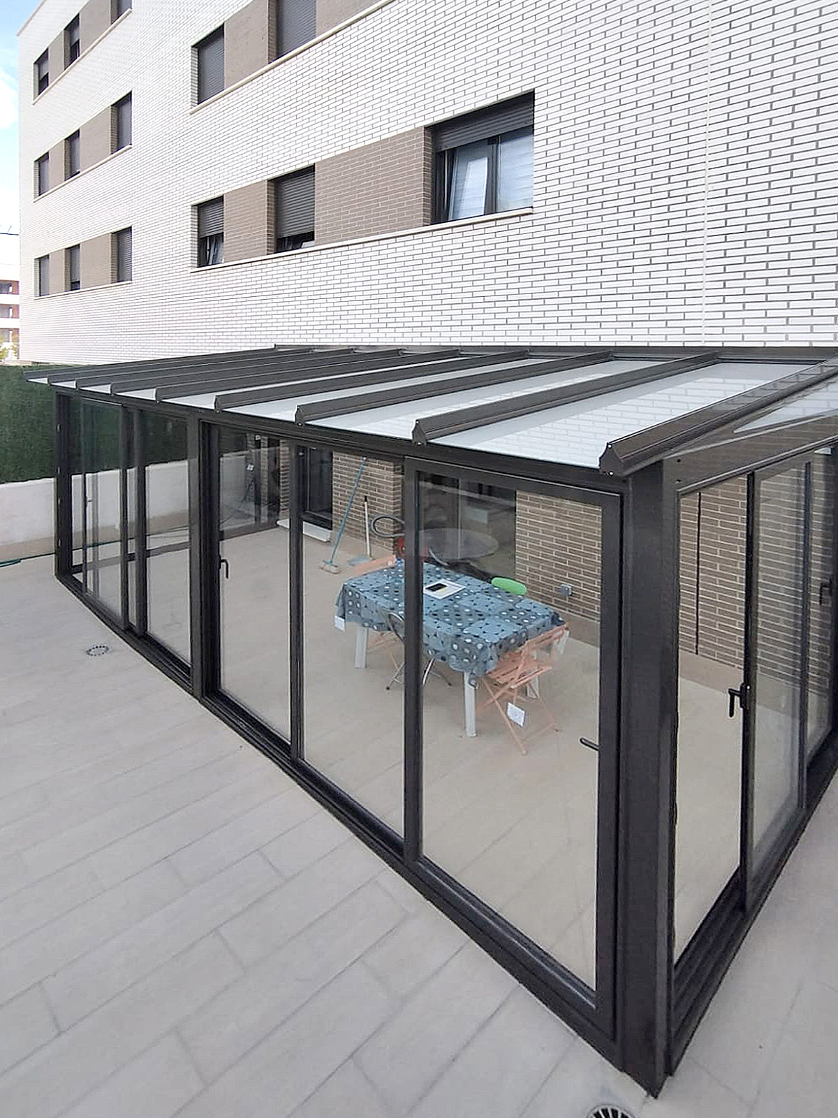 Instalación de cerramiento de aluminio en Zizur, Navarra.  Techo fijo de vidrio mate. Cerramientos inferiores de puertas correderas de aluminio.
