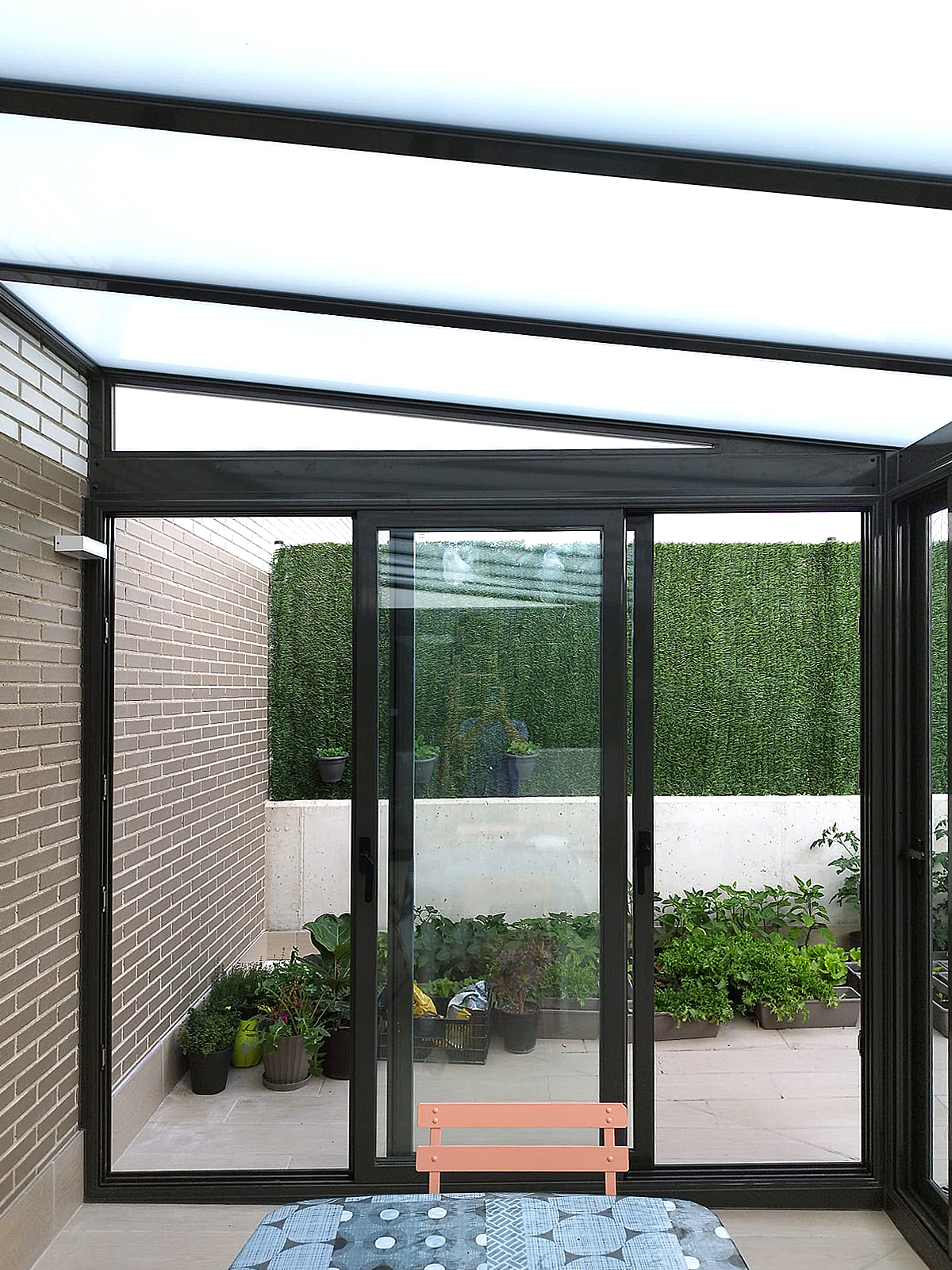 Instalación de cerramiento de aluminio en Zizur, Navarra.  Techo fijo de vidrio mate. Cerramientos inferiores de puertas correderas de aluminio.