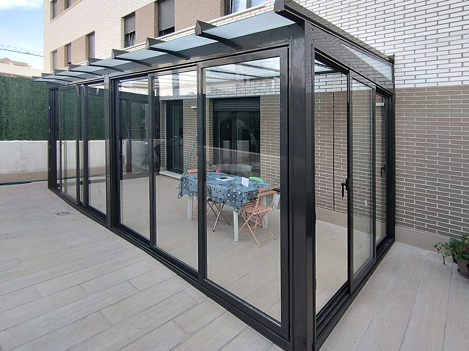 Instalación de cerramiento de aluminio en Zizur, Navarra.  Techo fijo de vidrio mate. Cerramientos inferiores de puertas correderas de aluminio.