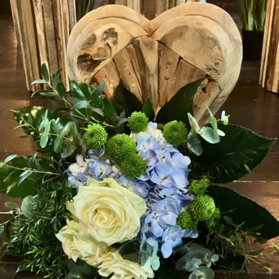 Eine Hortensie liegt während einer Trauerfeier vor einem Holzherz in der Friedhofskapelle Sankt Andreasberg