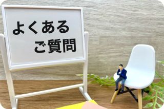 ホワイトボードに書かれたよくあるご質問の文字と椅子に座った男性画像