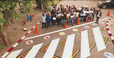 コンペで選ばれた地元学生デザインと、学生によって塗装した横断歩道（大学敷地内、2023年8月18日）