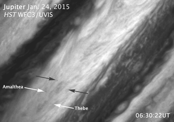 Abb. 38: Animation der Vorbeizüge von Amalthea und Thebe über Jupiter innerhalb einer halben Stunde, aufgenommen am 24. Januar 2015 von Hubble. Die weißen Pfeile zeigen die Monde, die schwarzen zeigen die Schatten. © HST WFC3/UVIS