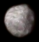 Kombinierte Farbaufnahme von Puck mit seinem großen Krater Bogle (rechts) von Voyager 2 am 24. Januar 1986 aus einer Entfernung von 493.000 Kilometern.