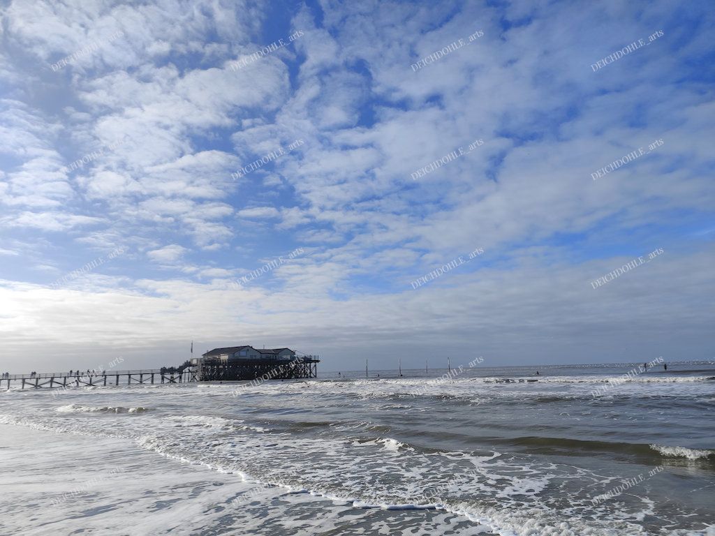 typische Pfahlbauten in St. Peter Ording unter einem besonders stimmungsvollen Himmel