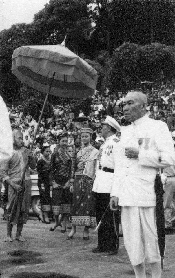 LA PRINCESSE MANILAY CONDUITE AU PALAIS PAR UN DE SES ONCLES TIAO VONG RATTANA, COLONEL ET AIDE DE CAMP DE SA MAJESTE. A SA DROITE LES DEMOISELLES D'HONNEUR DONT 2 SOEURS DE LA PCESSE OUANNA SOUVANNA PHOUMA.. AU 1er PLAN LE JUGE PAYA KAMPTON PRADITH.