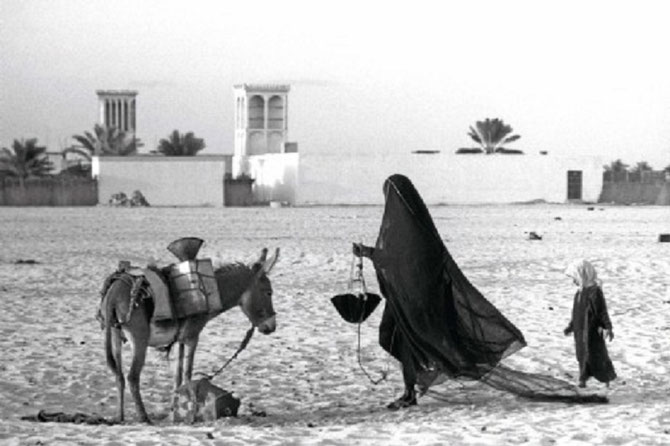 Une femme puisant de l'eau à l'extérieur du Fort Qasr el Horn