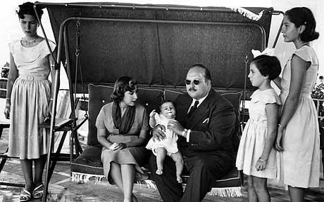 1952.ROME. LA PRINCESSE FADIA DEBOUT A COTE DE SON PERE ROI FAROUK Ier TENANT LE ROI FOUAD II DANS SES BRAS.