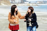 いわき市の勿来海水浴場で、来し方行く末を語ってくれた浪江実央さん（左）と伊藤遙さん。大好きだった双葉町の海にはいつ戻れるか分からない