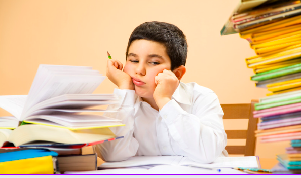 bambino con i pugni sul viso e tanti libri 