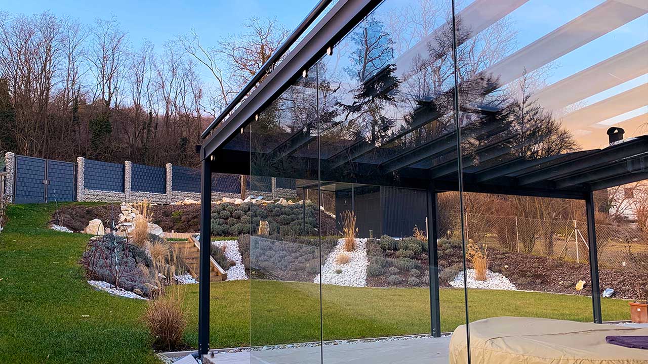Moderne Pergola mit Glasdach für einen lichtdurchlässigen Schutz gegen Schnee und Regen