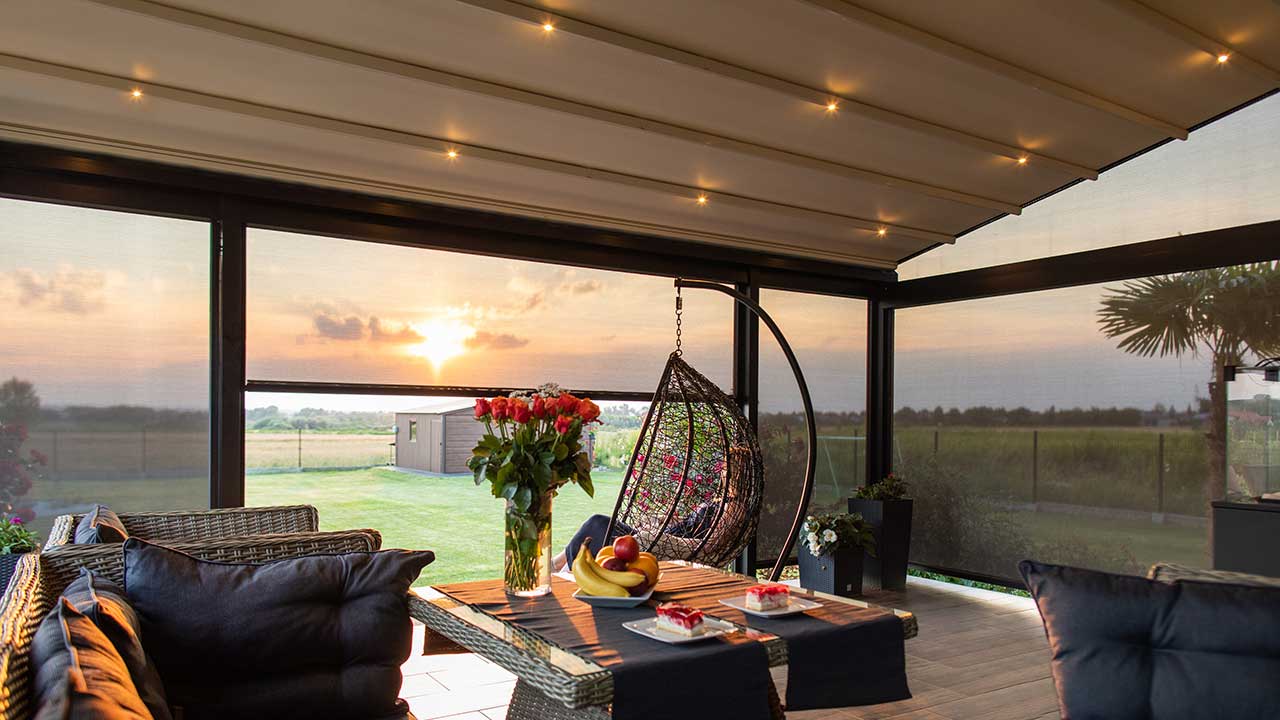 Moderne wandmontierte Pergola im schönen Garten mit integriertem ZIP-Screen. Genügend Platz für einen Hängesessel.