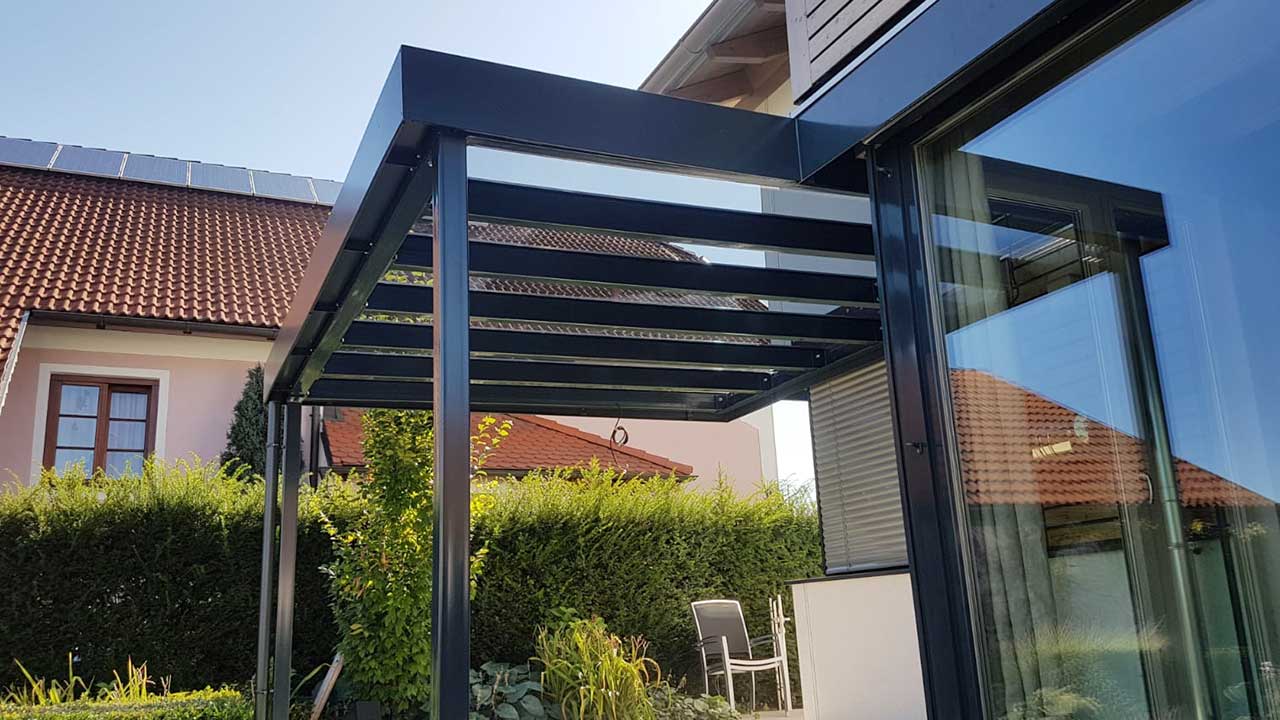 Moderne Pergola mit Glasdach für einen lichtdurchlässigen Schutz gegen Schnee und Regen