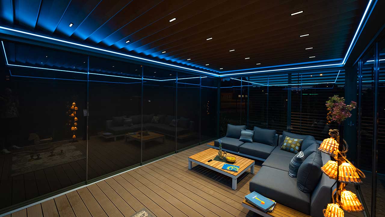 Moderne Lamellendach Pergola am Abend mit LED Belechtung in Szene gesetzt