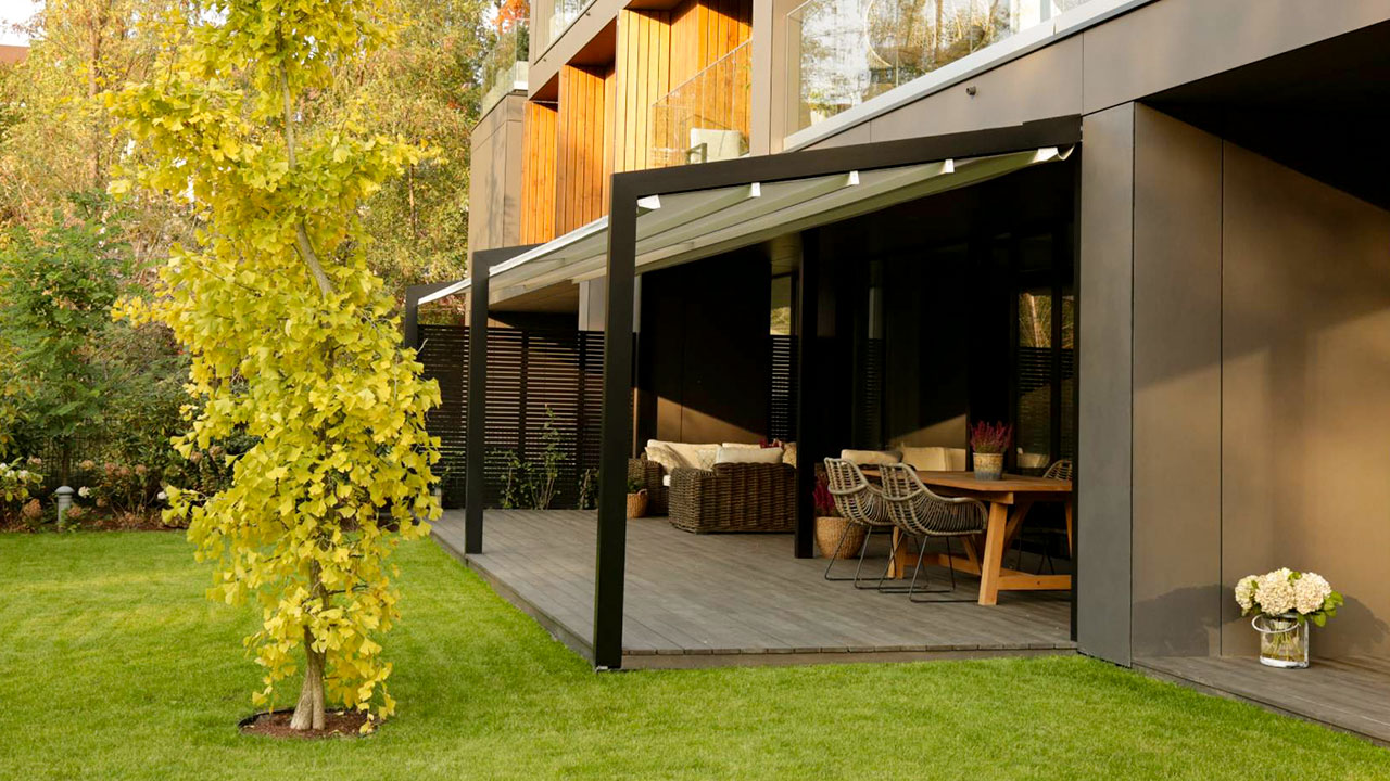 Wunderschöne Pergola für deine Terrasse. Holzboden mit Couch und Esstisch.