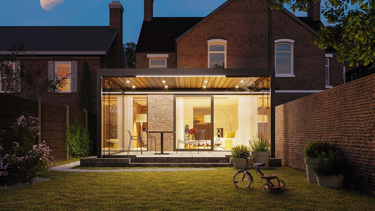 Moderner beleuchteter Sommergarten, Pergola direkt an das Haus montiert.