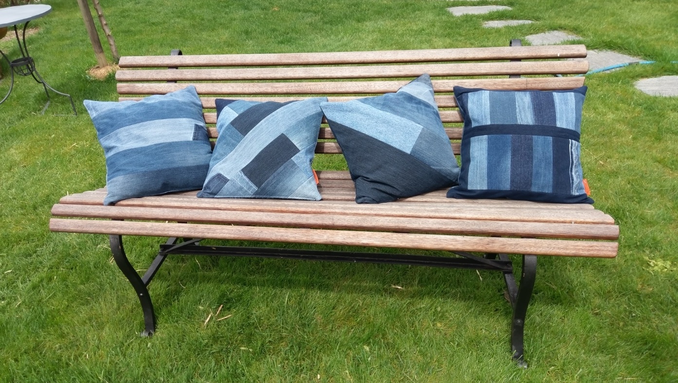 4 Patchwork Jeanskissen auf alter Holzbank im Garten