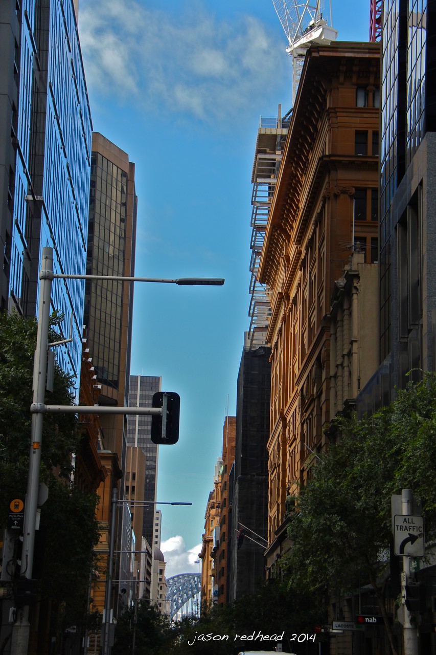  25-11-14 towering above all the commuting ants; cycling through the city to my soccer game tonight and saw this glimpse of sydneys icon hidden behind these heritage and modern buildings that make up the cbd. pitt street mall, nsw