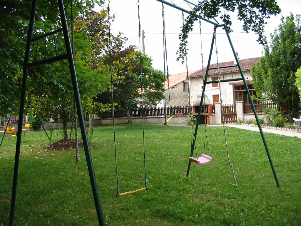 Le jardin : bac à sable, deux portiques, barbecue, mini-jardin de plantes aromatiques. 