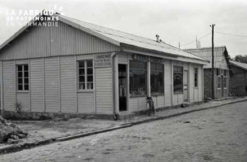 Baraquements de la reconstruction (commerce au premier plan)